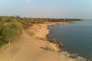 A view across Lake Malawi, with drylands on the left and the lake on the right.