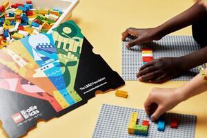Mains de deux enfants jouant avec des LEGO Braille bricks