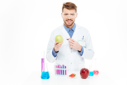 Male chemist injecting into apple isolated on a white background