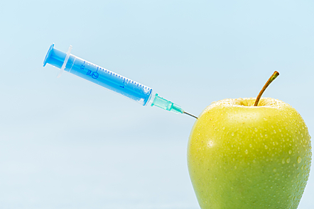 Injecting green apple medical syringe genetically modified foods
