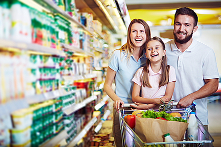 Ecstatic family with shopping cart with food visiting supermarket