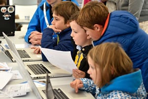 Group of young people on laptops learning how to code 