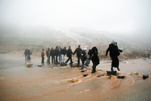 Refugees crossing a river