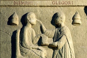 An ancient stone carving depicting a doctor treating a patient