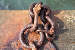 A steel chain appearing as a knot, showing signs of corrosion and material loss.