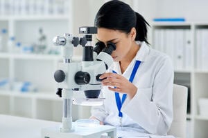Shot of a young scientist using a microscope in a laboratory.