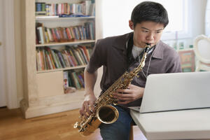 Asian boy playing saxophone 