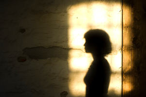 Shadow of a woman on a brightly lit section of wall