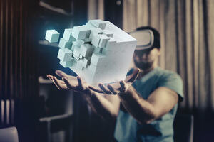 A man wearing a virtual reality headset imagines he is holding a moving block of cubes in the air. 