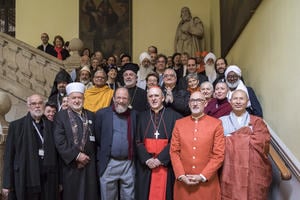 A group of religious leaders from around the world smiling and standing together for a photograph