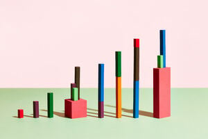 Colourful blocks are lined up in a bar chart formation in a pink and green room. 