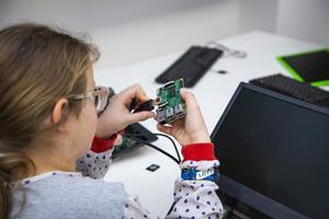 A girl plugging a HDMI cable into a Raspberry Pi