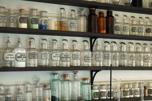 Clear old fashioned labelled bottles on a shelf in a pharmacy