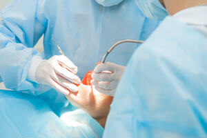Dentists use medical equipment to clean patients' teeth