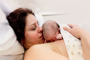 Blissful mother and baby cuddling immediately after birth. Copyright Brisbane Birth Photography.