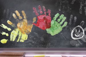 School blackboard with colourful handprints